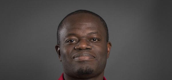 Headshot of Nabil Afodjo on black background 